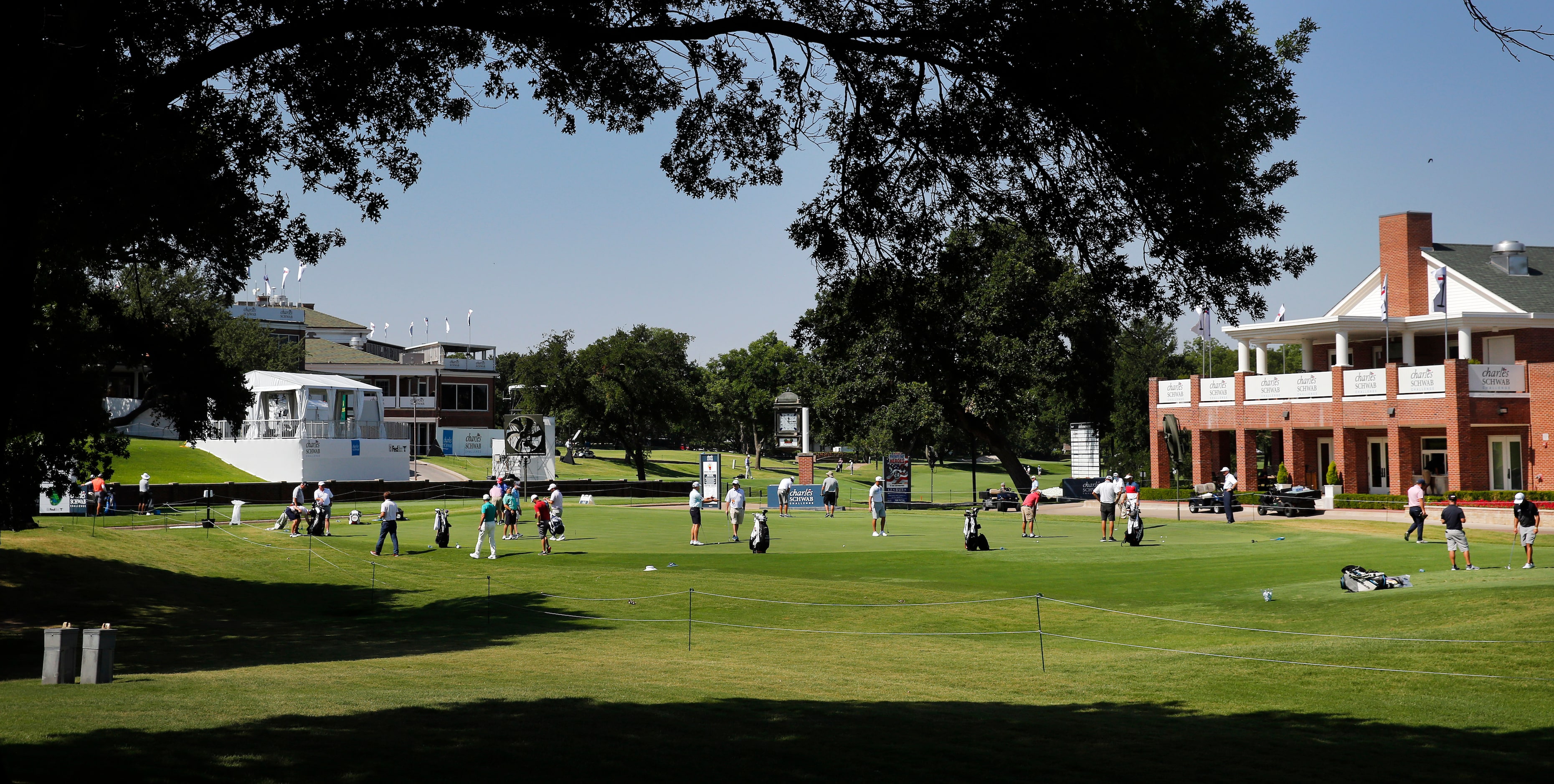 PGA golfers work on their putting and chipping around the practice greens during the Charles...