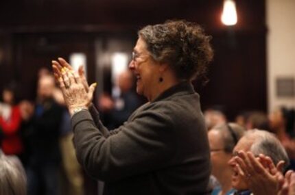  A woman stands up to applaud Republican presidential candidate Ben Carson as he speaks at a...