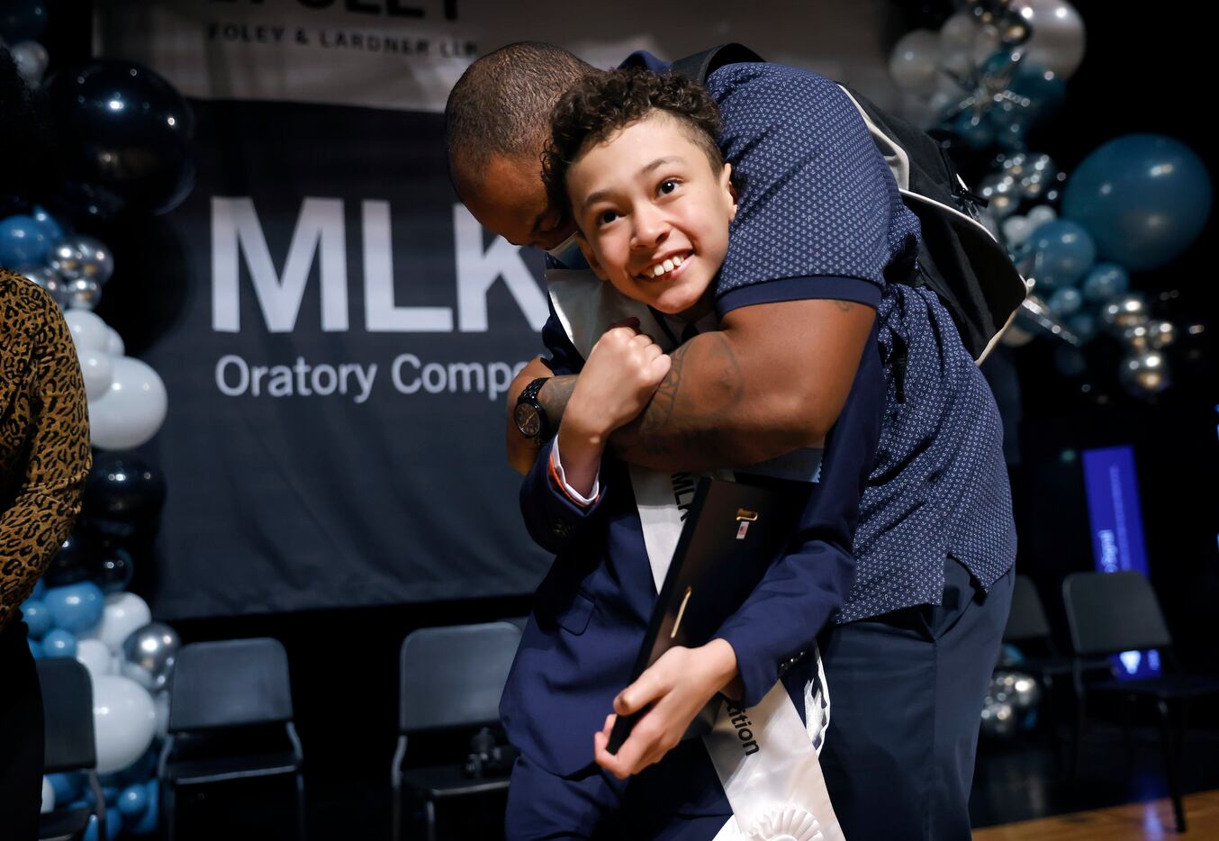 Fifth grader Tristan Whitfield of Paul L. Dunbar Learning Center receives a hug from his...