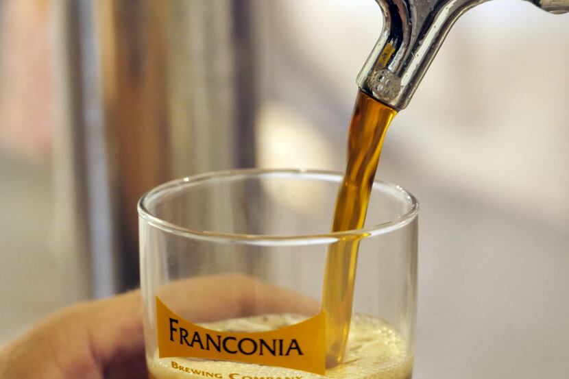Dennis Wehrmann, owner of Franconia Brewing Company in McKinney pours samples of his product...