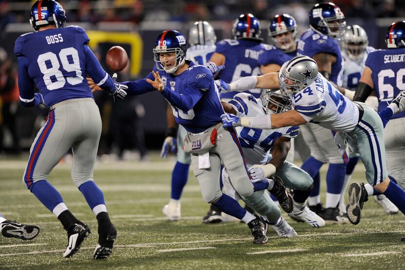 FILE -- The Giantsâ Eli Manning, second from left, tosses the ball during a game against...