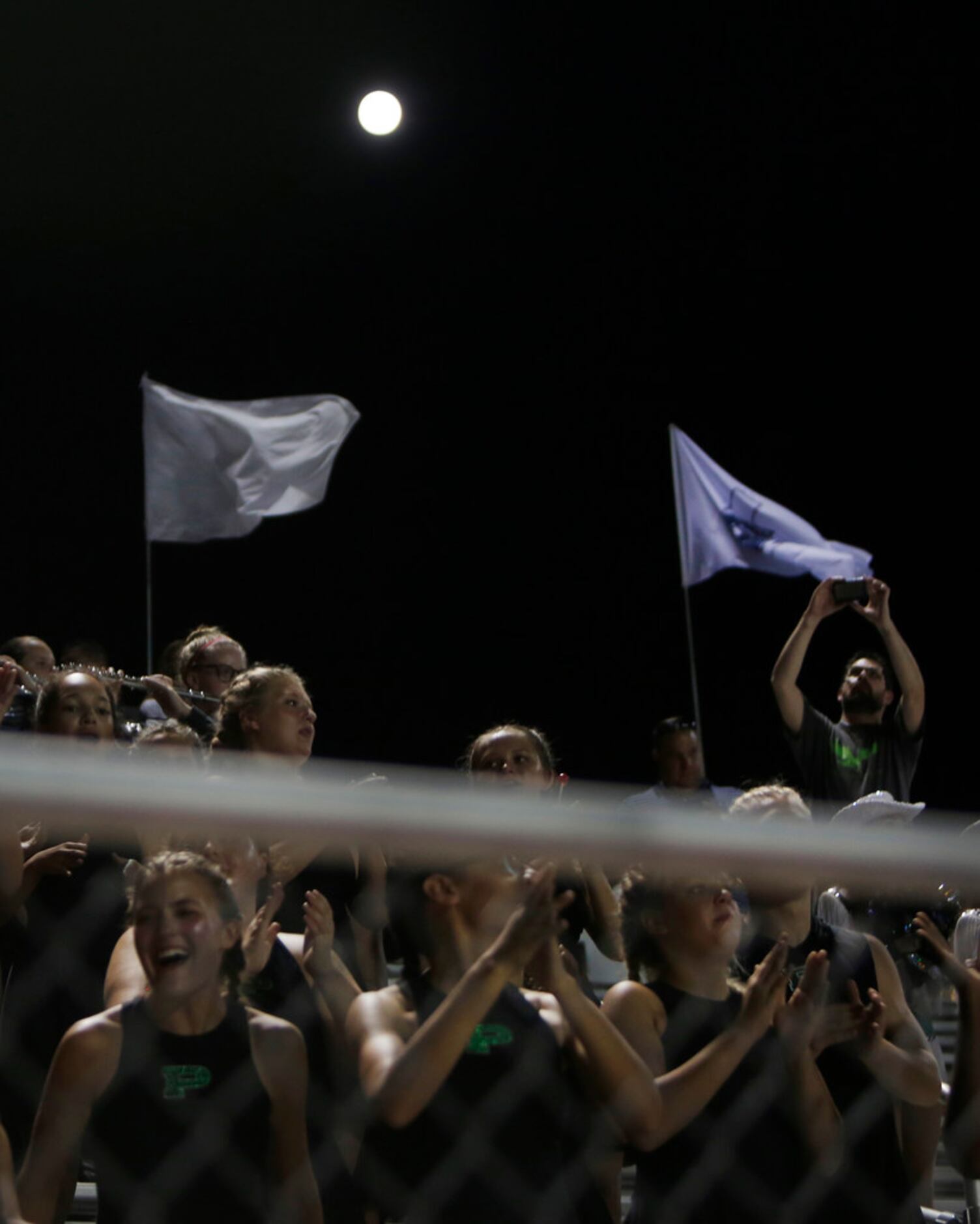 Under a harvest moon, members of the Prosper drill team cheer as the final seconds run off...
