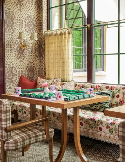 A banquet sits in front of a window with tables in front and another chair at the table.