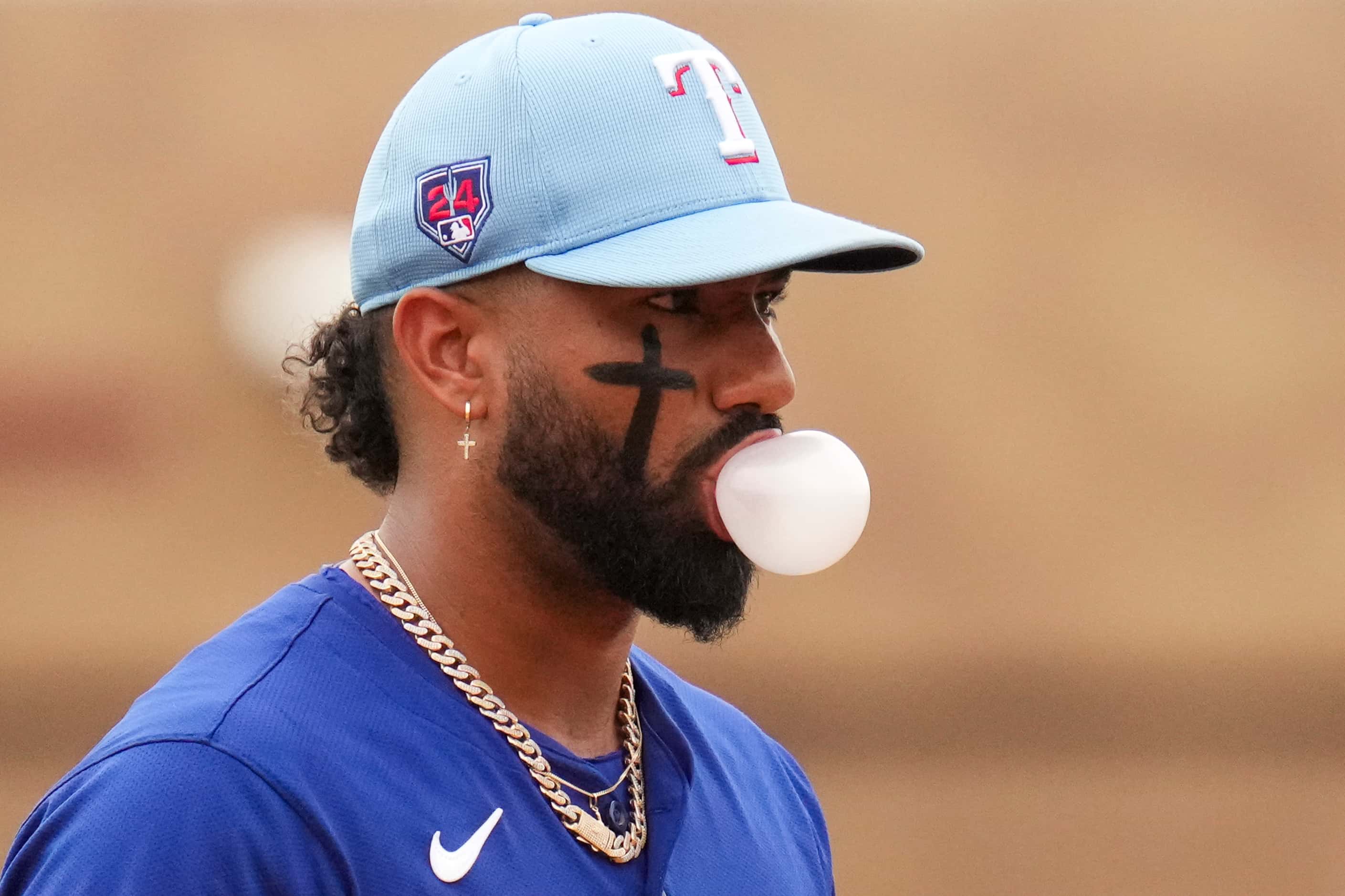 Texas Rangers Ezequiel Duran blows a bubble during the first inning of a spring training...