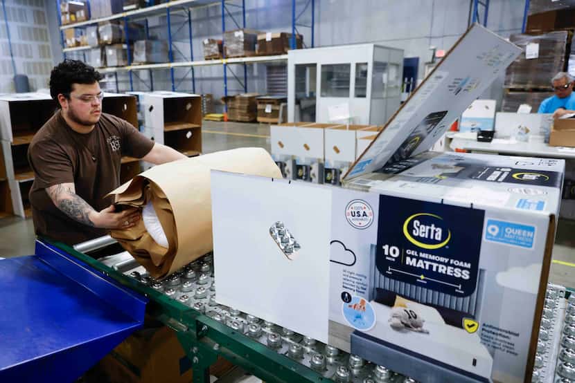 Milton Sleeping Company factory worker Jaden Aguilera packs a folded mattress in a box on,...