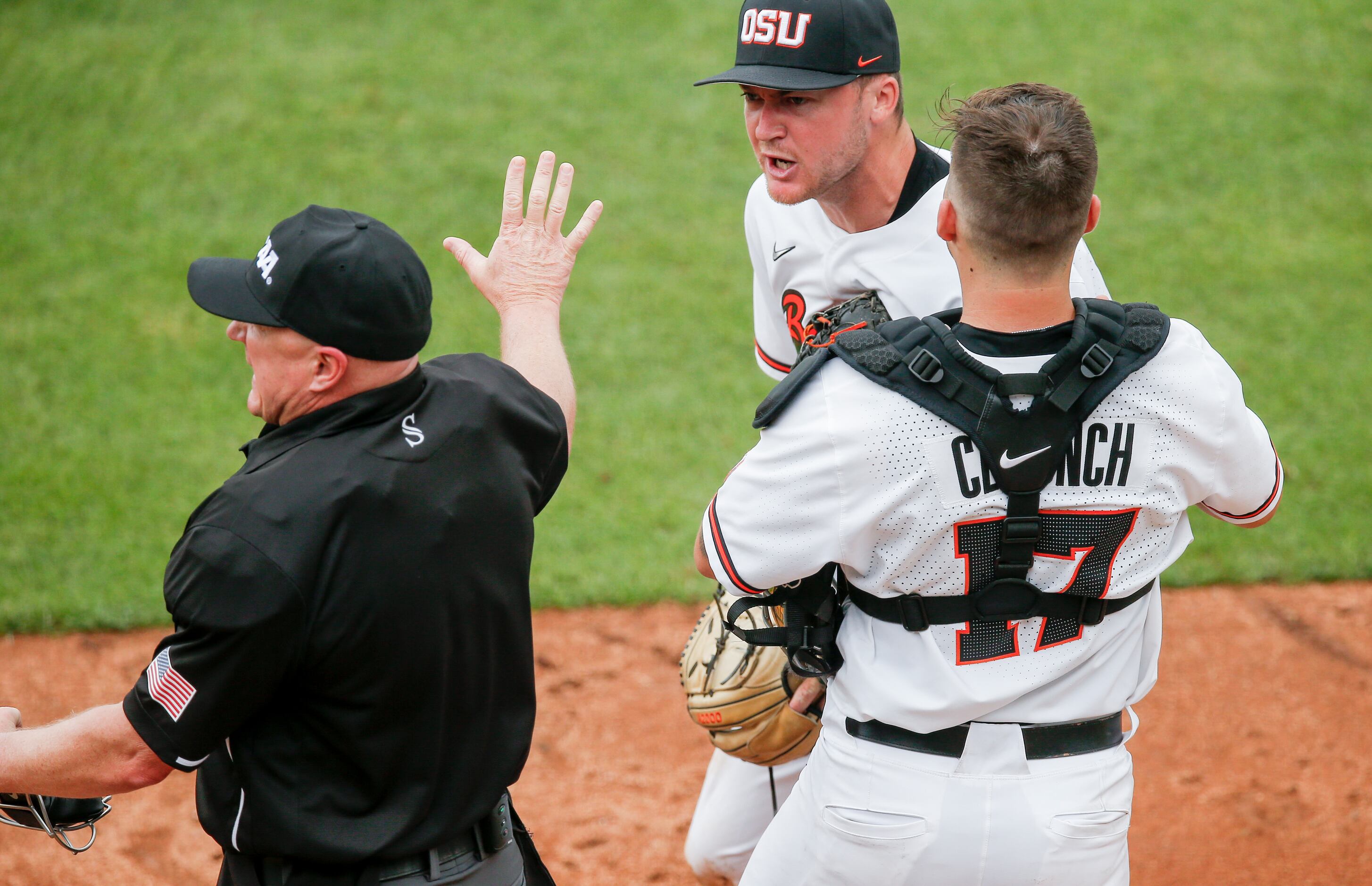 Oregon St. starting pitcher Kevin Abel (23) is restrained by catcher Troy Claunch (17) while...