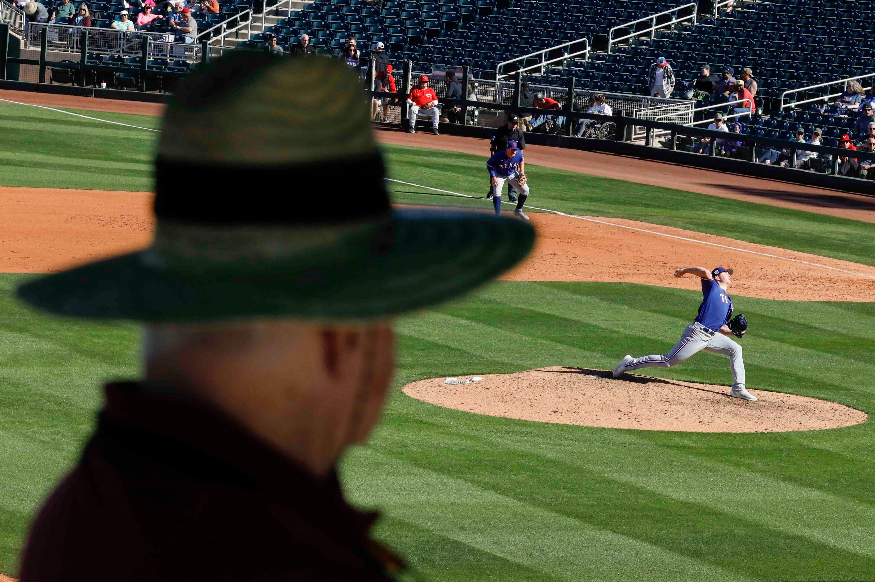 Volunteer watches as Texas Rangers pitcher Josh Sborz delivers during the sixth inning of a...