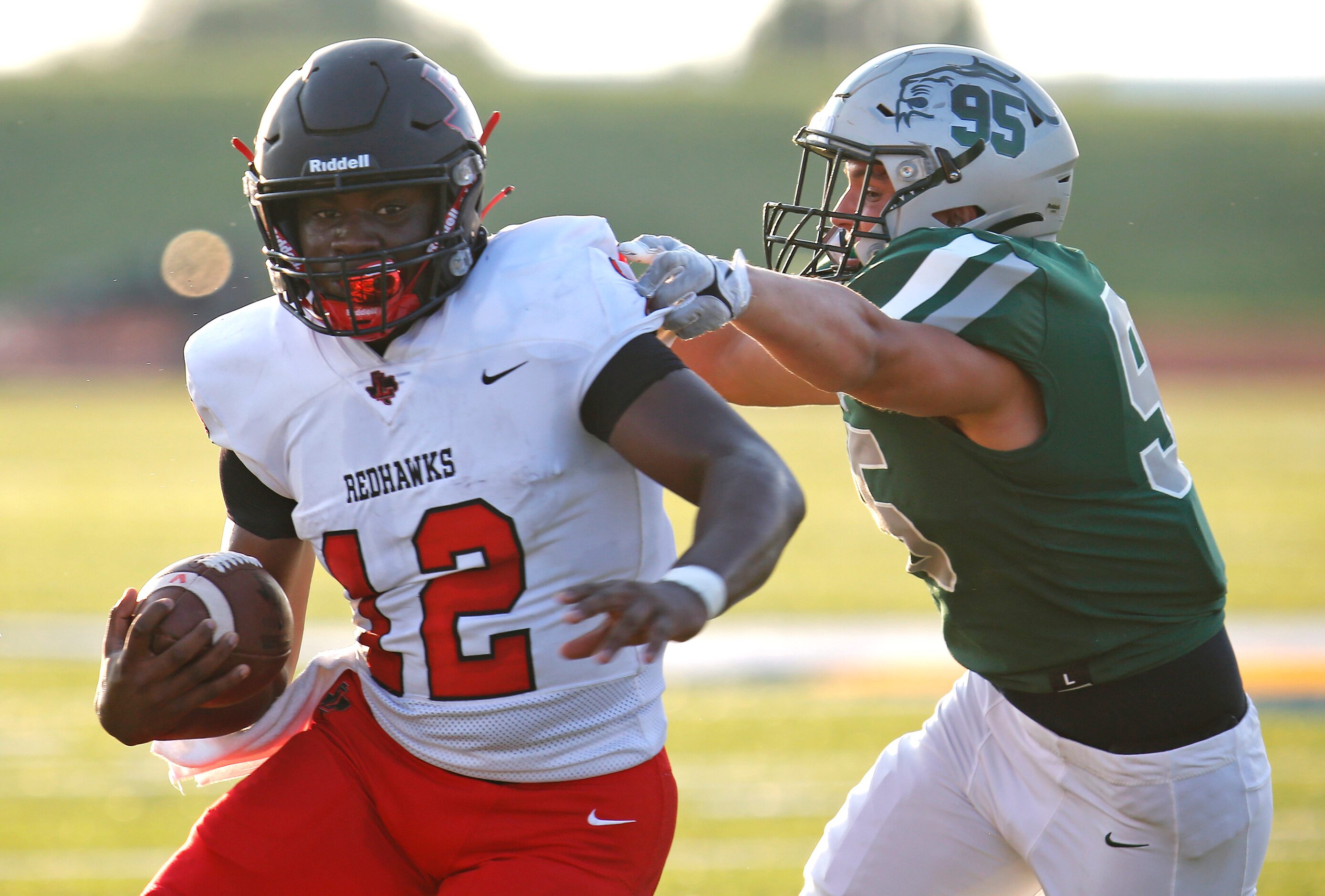 Liberty High School quarterback Keldric Luster (12) gets past Reedy High School defensive...