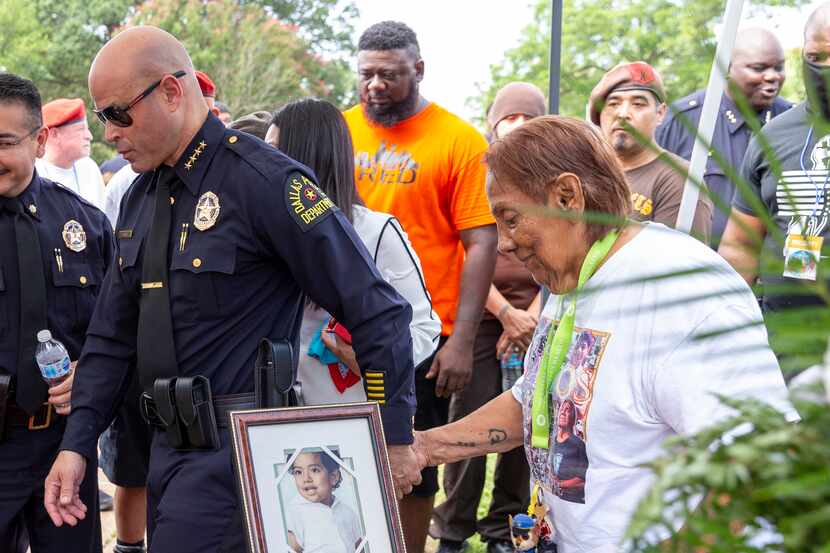 Dallas Police Chief Eddie Garcia (left) escorts Bessie Rodriguez, mother of Santos...