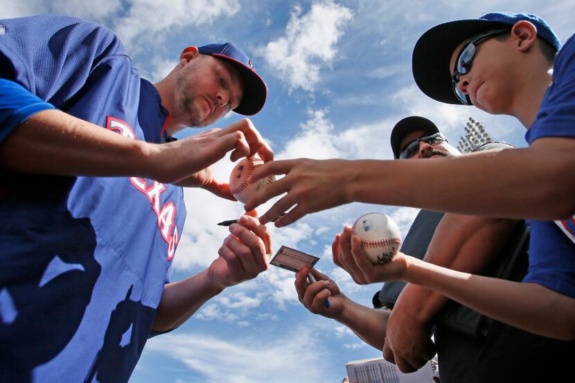 texas pitcher Matt Harrison signs autographs along the right field before the Kansas City...
