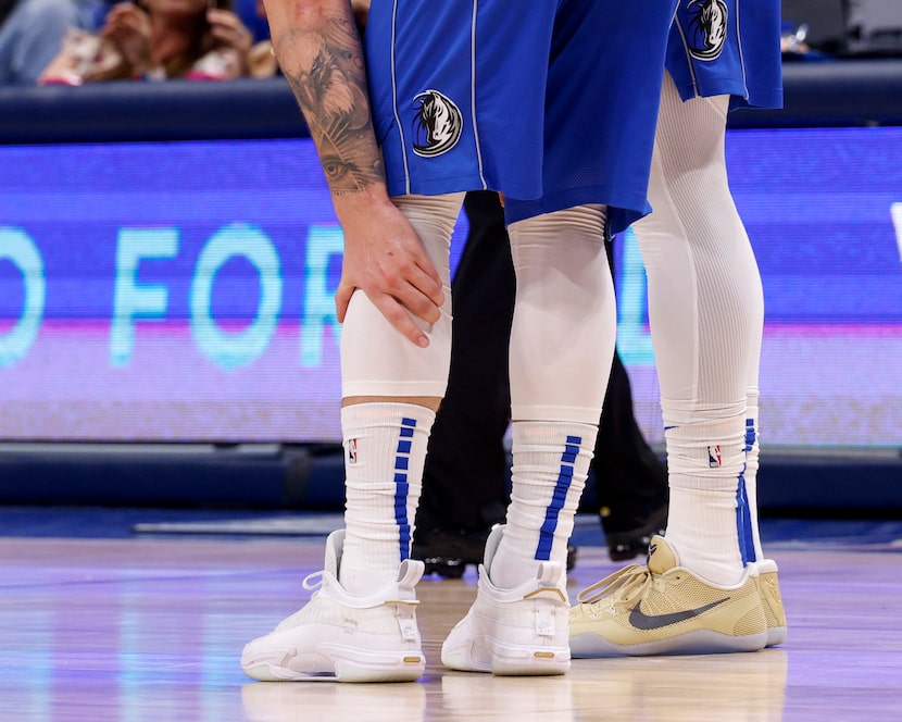 Dallas Mavericks guard Luka Doncic (77) clutches his lower left leg during the third quarter...