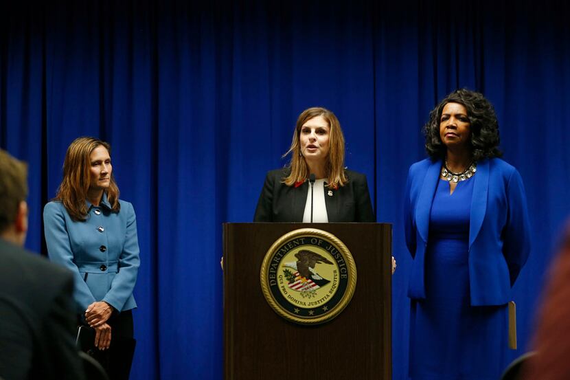 U.S. Attorney Erin Nealy Cox, center, at a news conference in July announcing the federal...