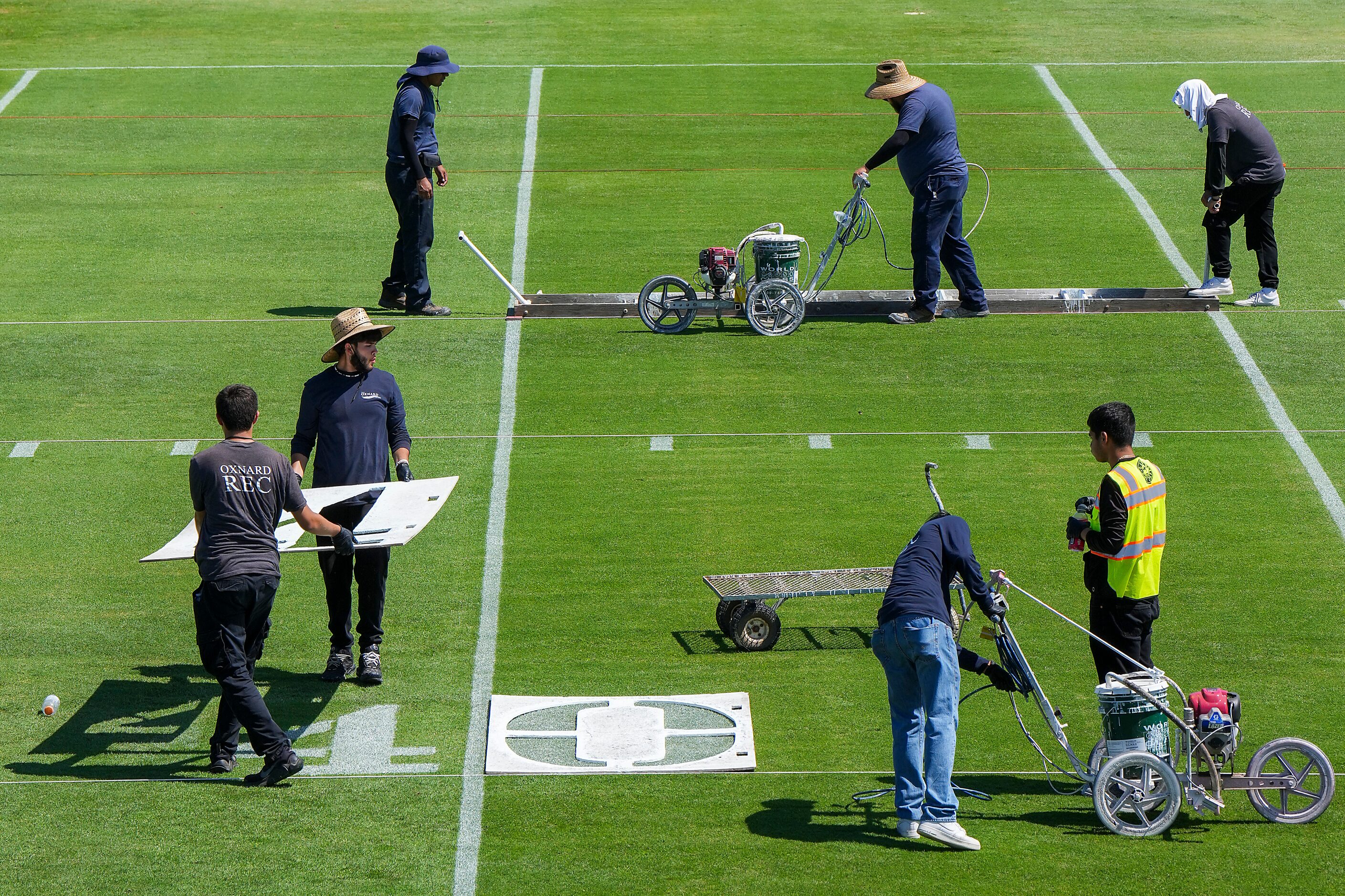 Workers prepare the field for Wednesday’s start of Dallas Cowboys training camp on Tuesday,...