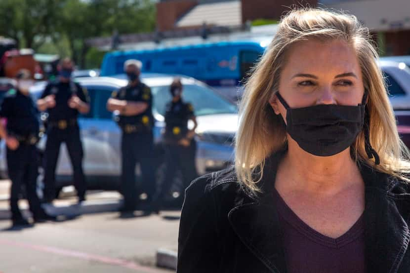 With Dallas officers standing by, Shelley Luther speaks with supporters in the parking lot...