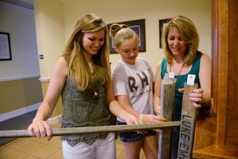 Caitlyn Emigh (far left), with her mom Janet and sister Mirana, 11, picks up her engraved...