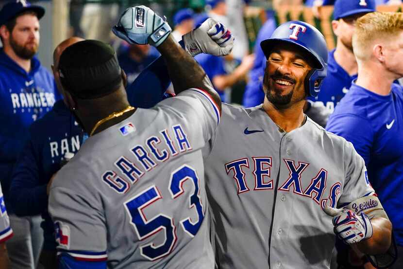 Texas Rangers' Marcus Semien, right, celebrates after his home run with Adolis Garcia during...