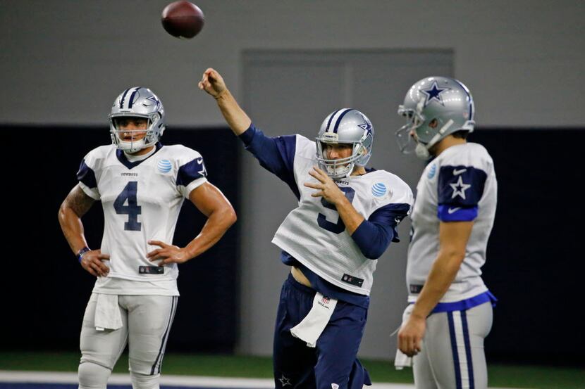 Dallas Cowboys quarterback Tony Romo (9) throws a pass as quarterback Dak Prescott (4) looks...