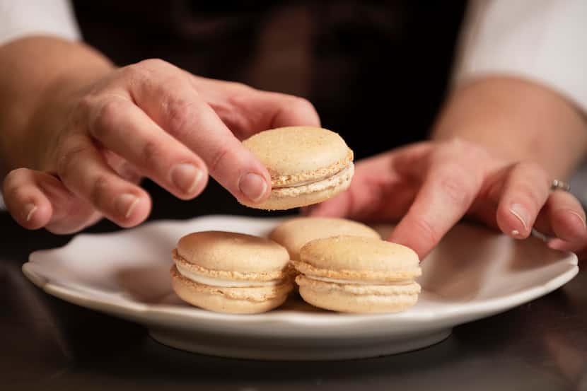 Andrea Meyer, of Bisous Bisous Patisserie, plates a group of churro-flavored macrons after...