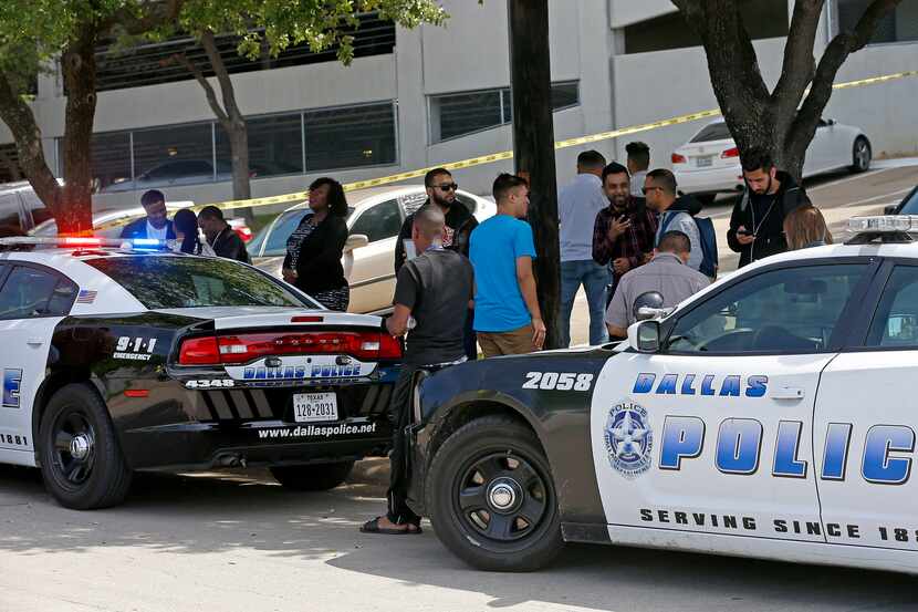 Workers stand outside the office building after a shooting was reported. (Jae S. Lee/Staff...