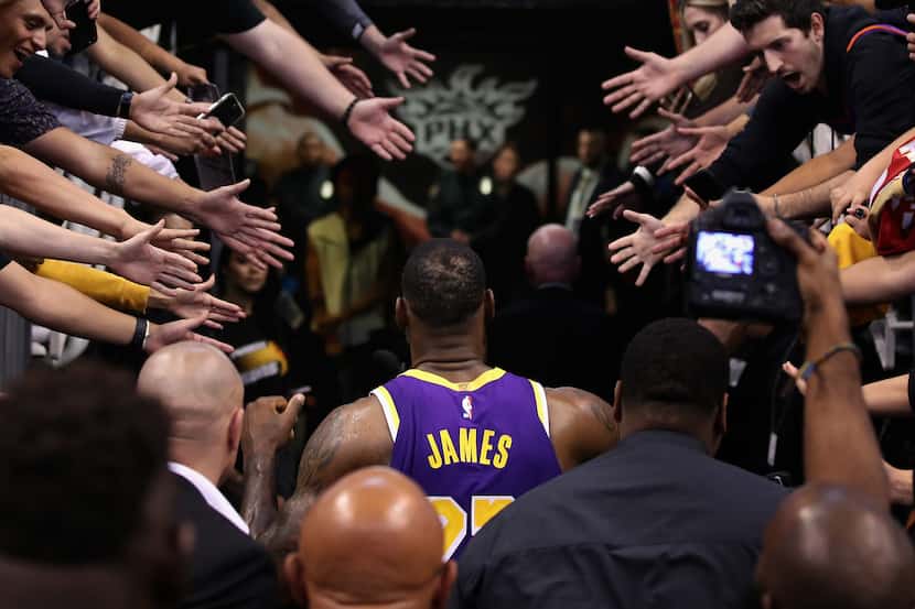 La estrella de los Lakers de Los Ángeles, LeBron James, pretende ser saludado por decenas de...