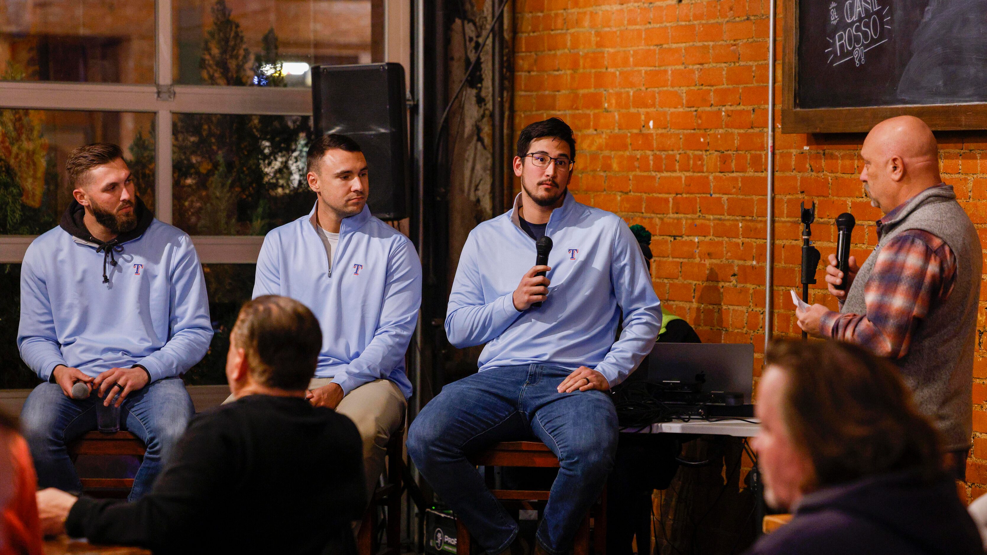 Texas Rangers pitcher Dane Dunning answers a question alongside Joe Barlow and Brock Burke...