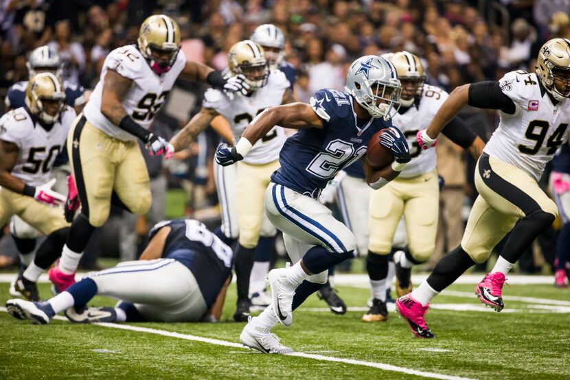 Dallas Cowboys running back Joseph Randle (21) runs through the New Orleans Saints defense...