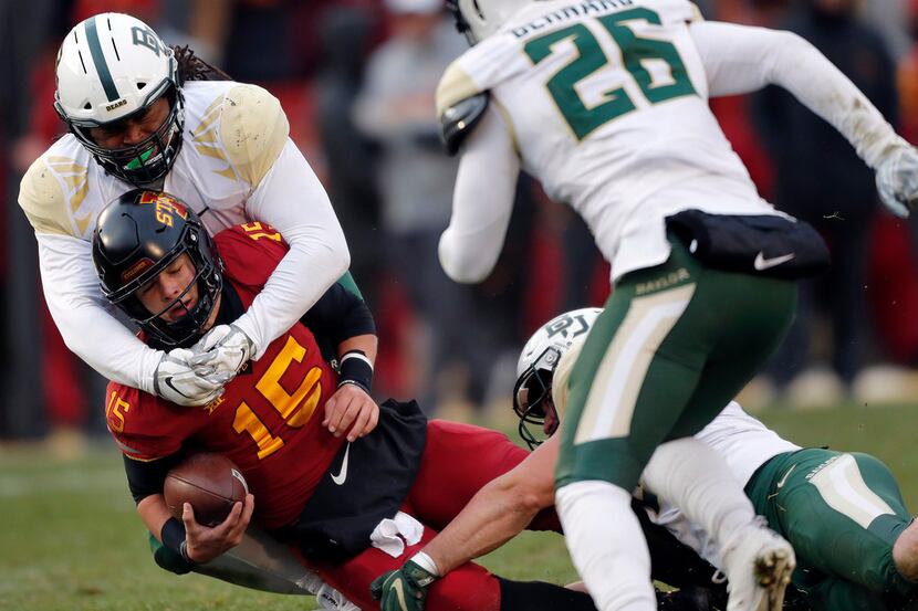 Iowa State quarterback Brock Purdy (15) is tackled by Baylor defensive tackle Bravvion Roy...