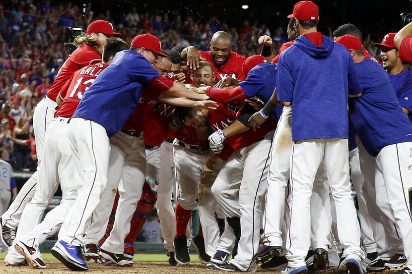 Texas Rangers first baseman Mitch Moreland (18) is congratulated by teammates for his walk...
