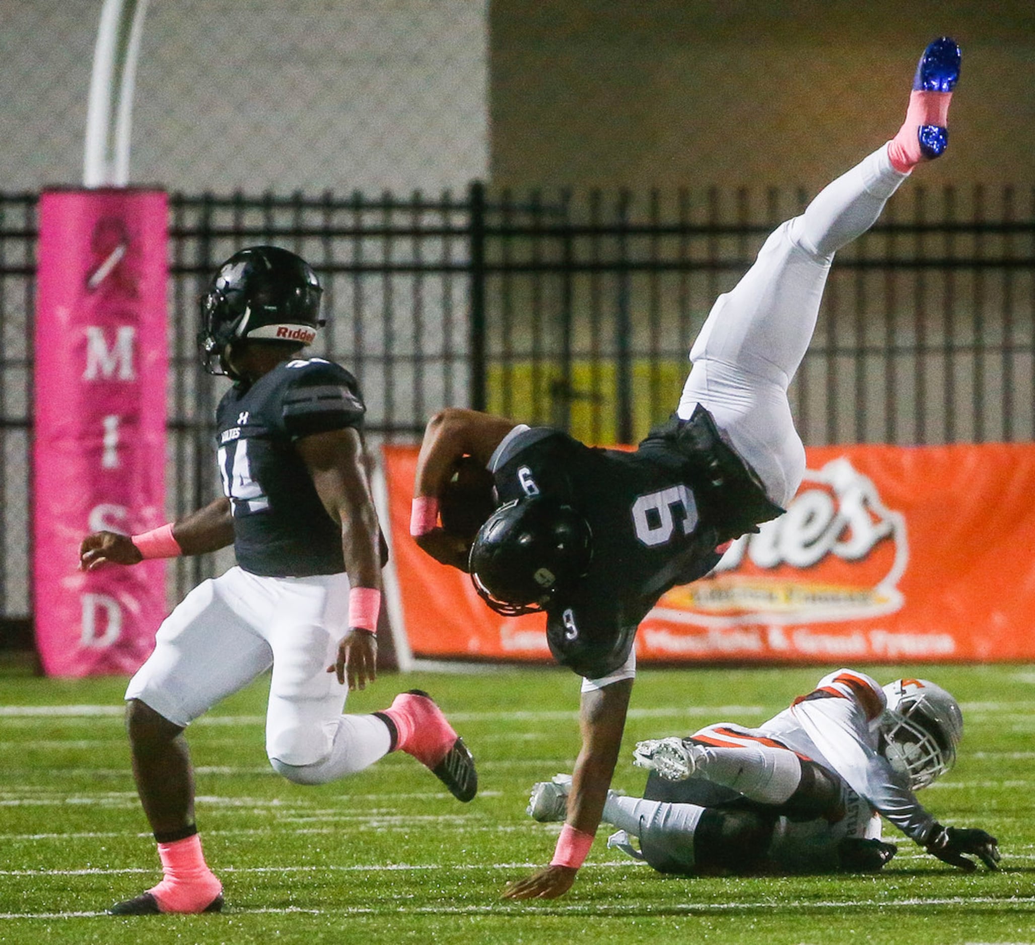 Mansfield Timberview's Jaden Hullaby (9) is upended by Lancaster defensive back Davion Hodge...