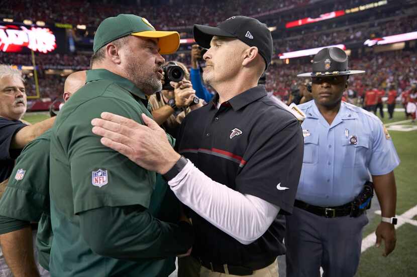 Green Bay Packers coach Mike McCarthy (L) shaking hands with Atlanta Falcons coach Dan Quinn...