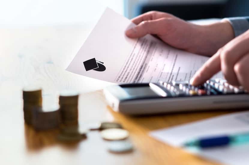 Un hombre realiza cálculos en documentos financieros relacionados con un préstamo estudiantil.
