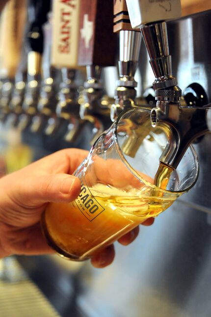 A bartender pours one of 36 available beers on tap at the grand opening of Old Chicago Pizza...