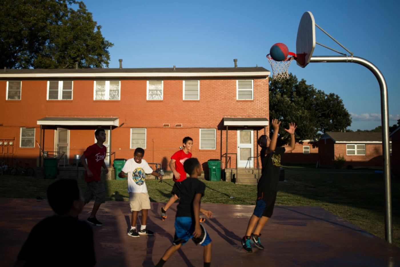 Neighborhood kids play baseball on the basketball court at Merritt Homes. (Ting Shen/The...