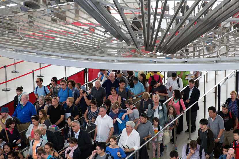 Passengers wait in a security line at John F. Kennedy International Airport in June.