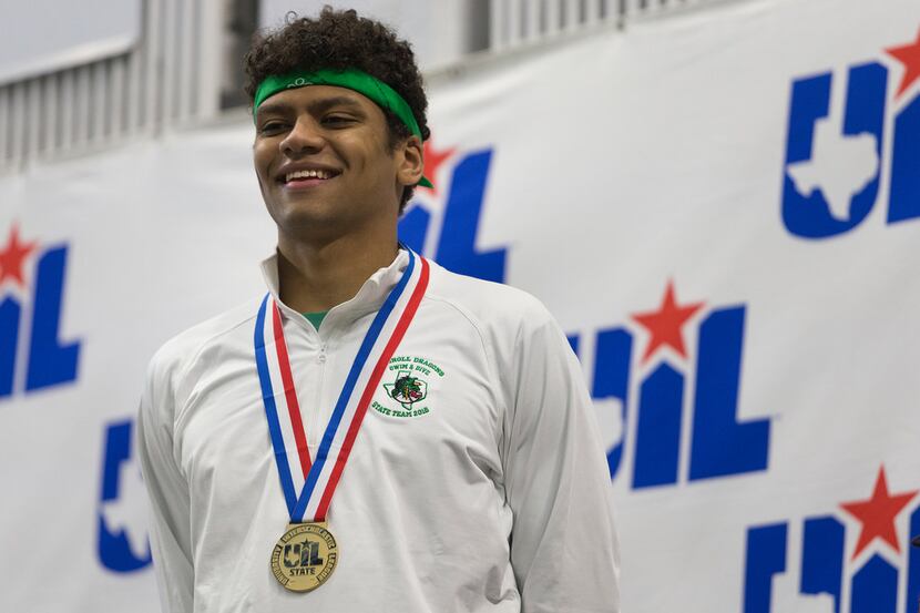 Southlake Carroll's Jack LeVant stands with his gold medal after finishing first and...