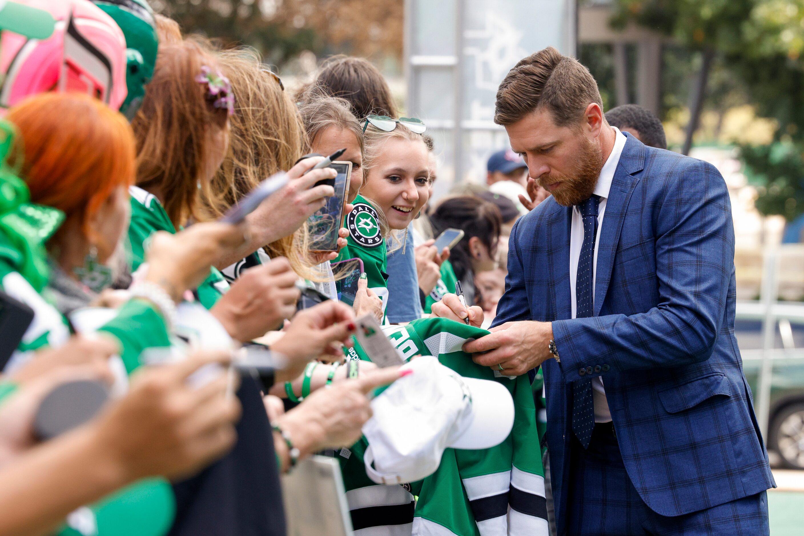 Dallas Stars center Joe Pavelski signs an autograph for a fan on the green carpet to the...