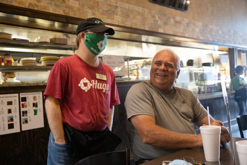 Blaine Hardin (left) chats with Hugs Café co-founder Chris Thompson and his family at the...