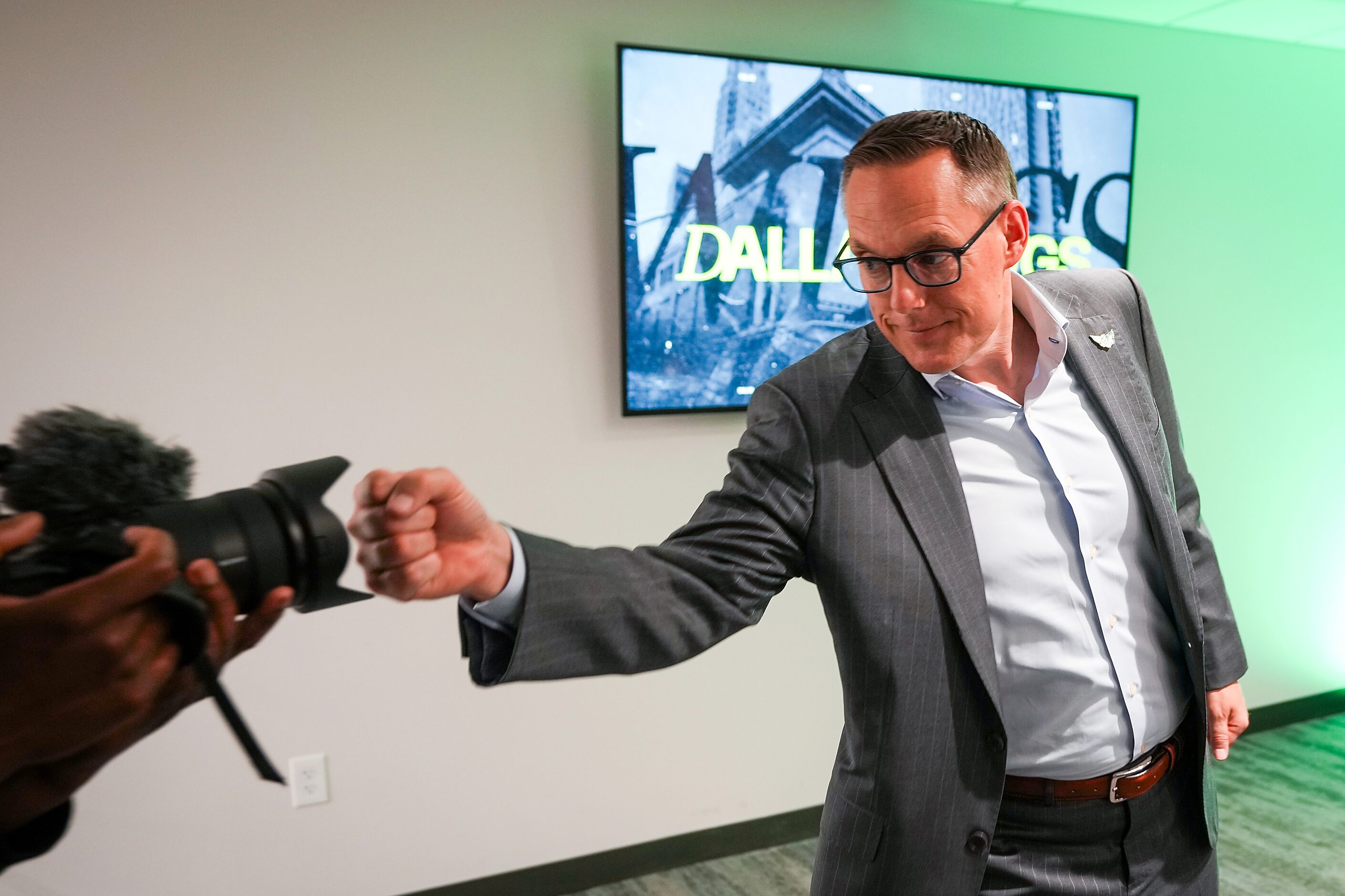 Dallas Wings President and CEO Greg Bibb fist bumps a camera in the team’s draft war room...