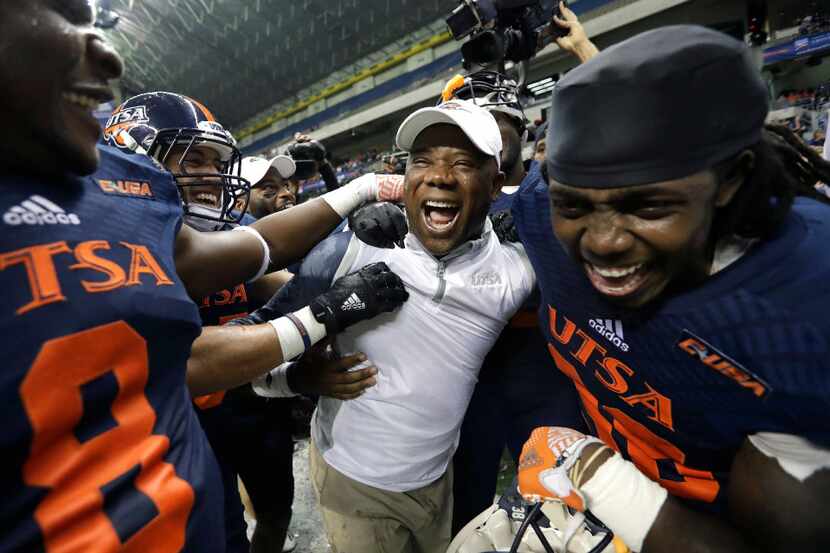 UTSA head coach Frank Wilson, center, and his players celebrate their win over Charlotte in...