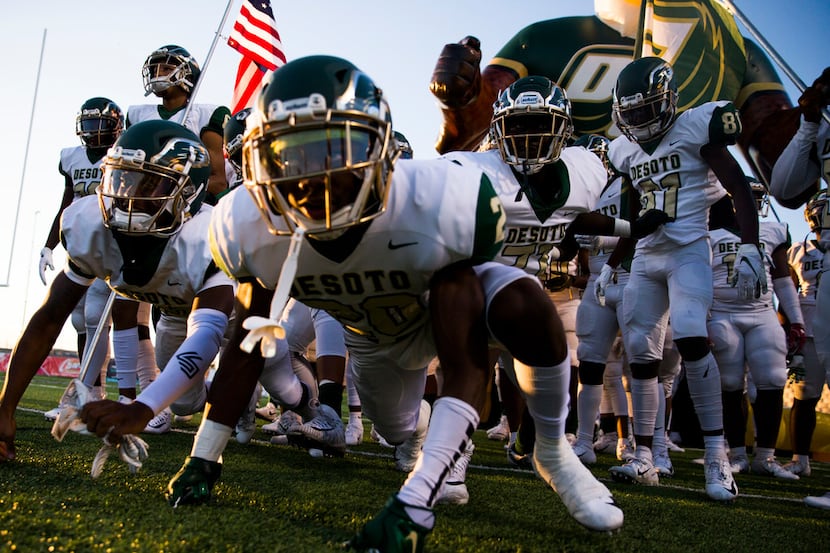 Desoto football players lunge toward the field from the tunnel before a District 7 6A high...
