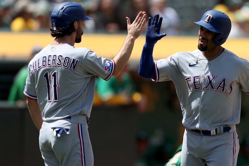 Texas Rangers' Marcus Semien, right, is congratulated by Charlie Culberson (11) after...