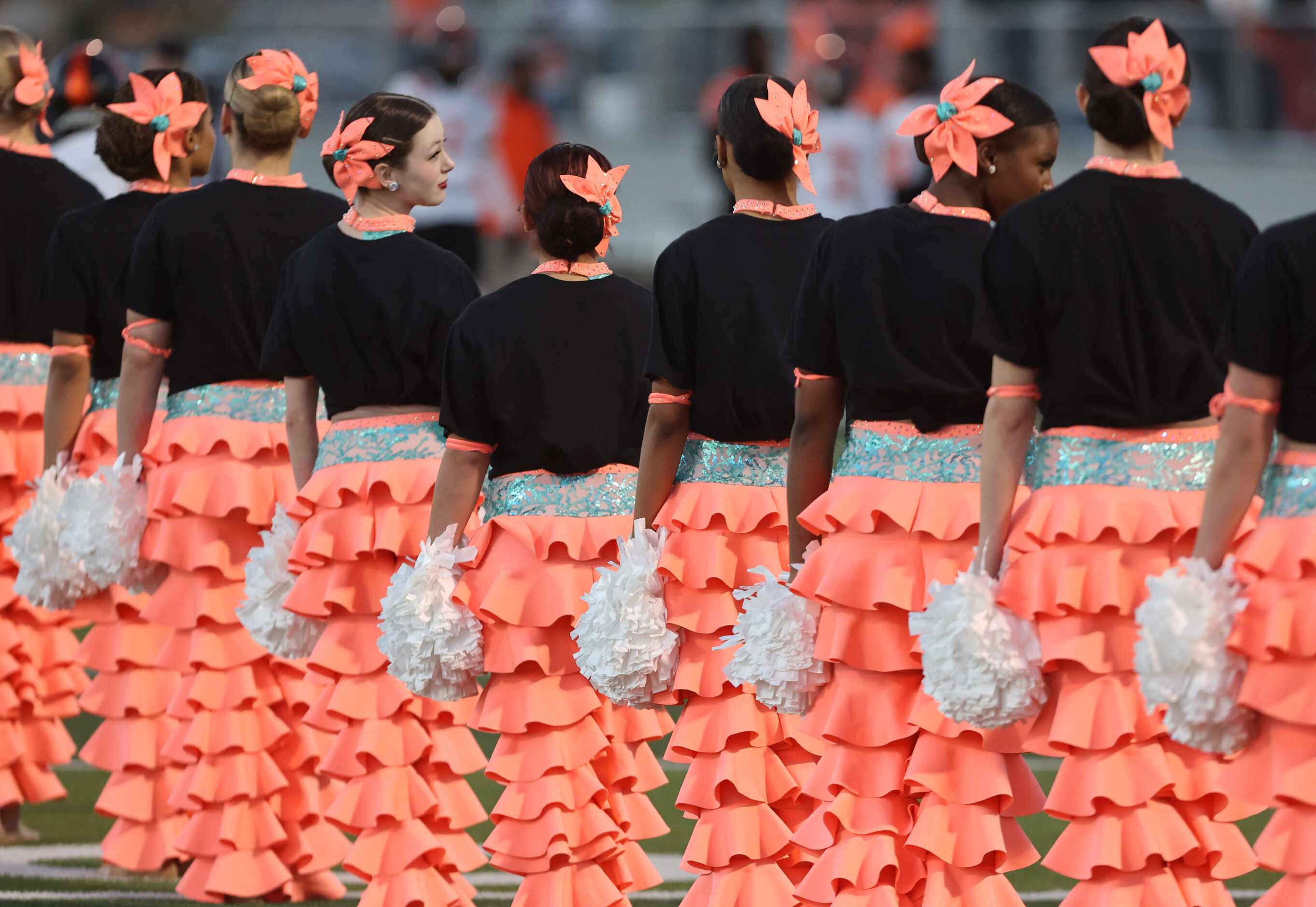 Costumed members of the Forney drill team hold their position prior to the start of the...