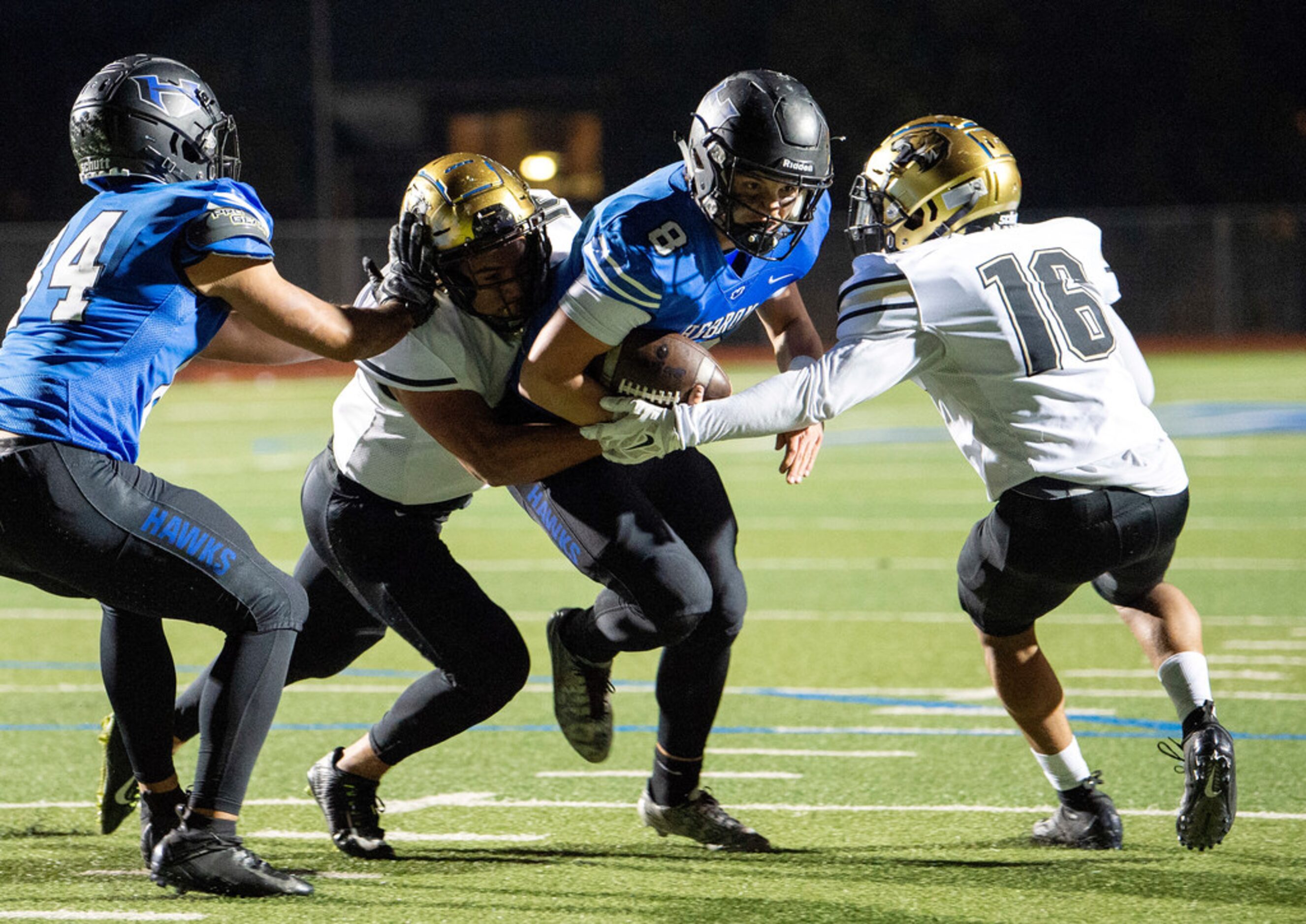 Hebron junior quarterback Carson Harris (8) fights through the the tackle of Irving...