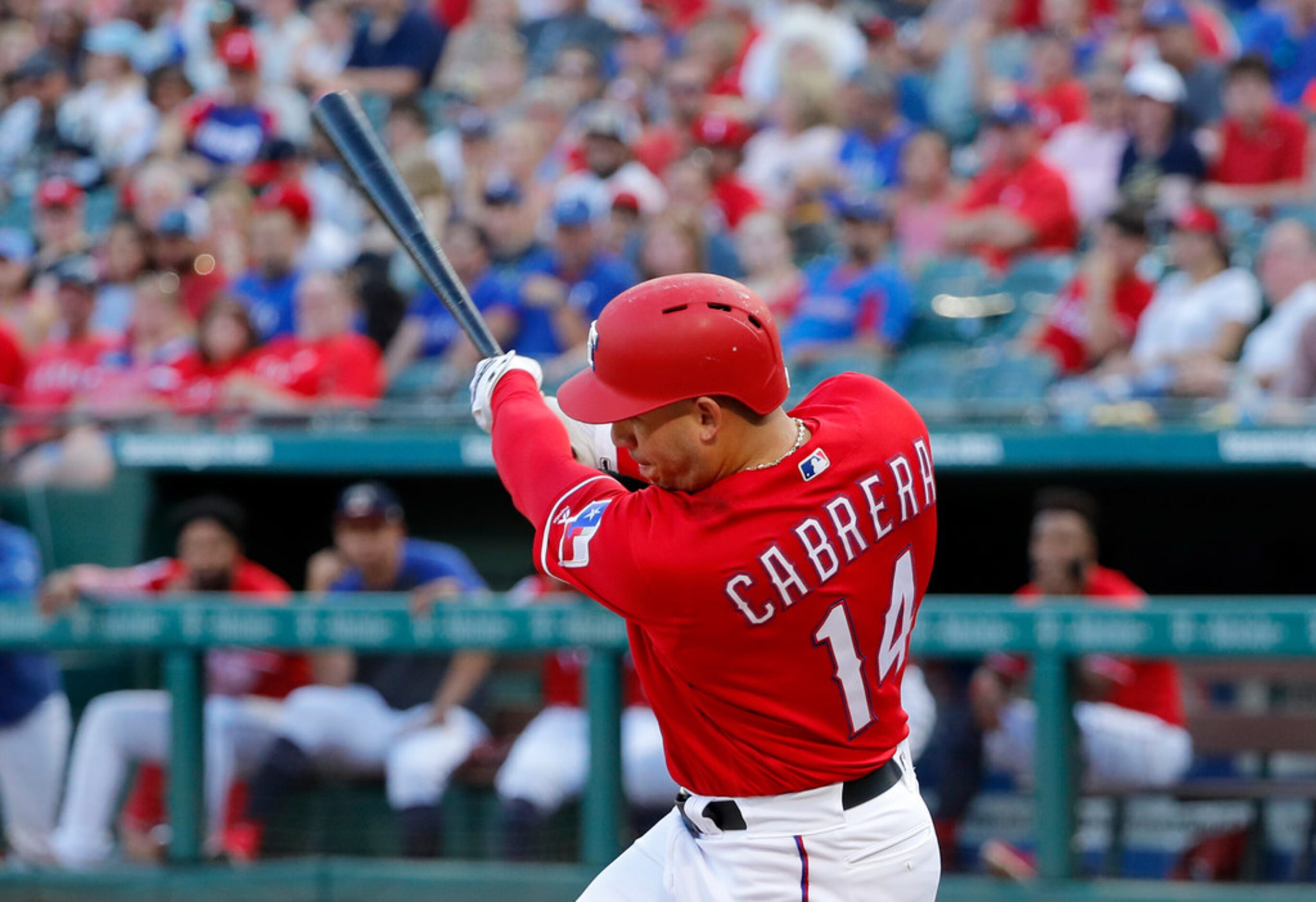 Texas Rangers' Asdrubal Cabrera follows through on a sacrifice fly to right off Los Angeles...