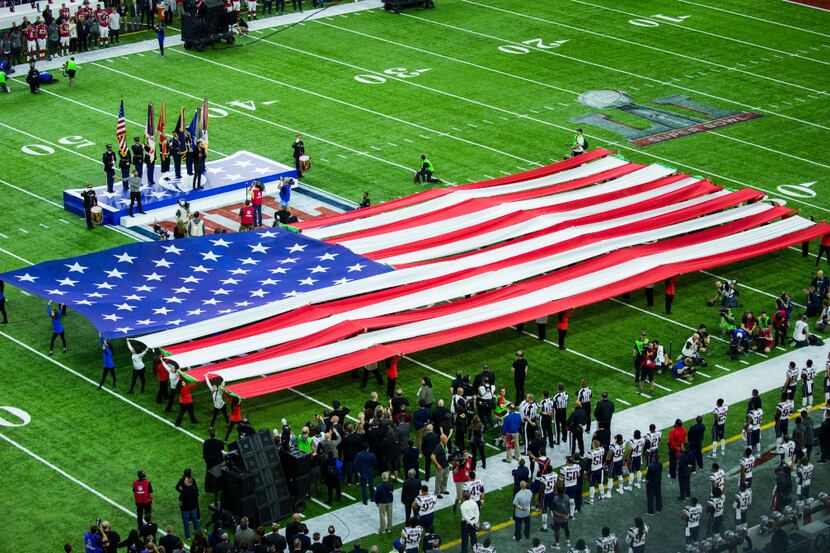 Musician Luke Bryan sings the national anthem before Super Bowl LI between the New England...