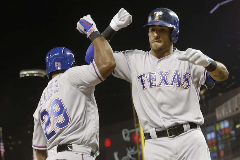 Texas Rangers' Ian Desmond, right, and Adrian Beltre celebrate Desmond's solo home run off...