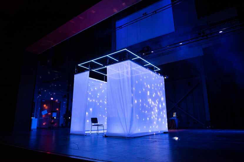 A curtained-off square serves as projection screen and audience pod in "The Cube" at the...