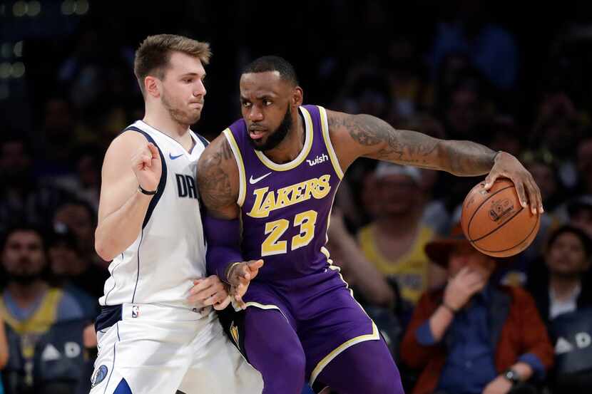 Los Angeles Lakers' LeBron James (23) is defended by Dallas Mavericks' Luka Doncic during...