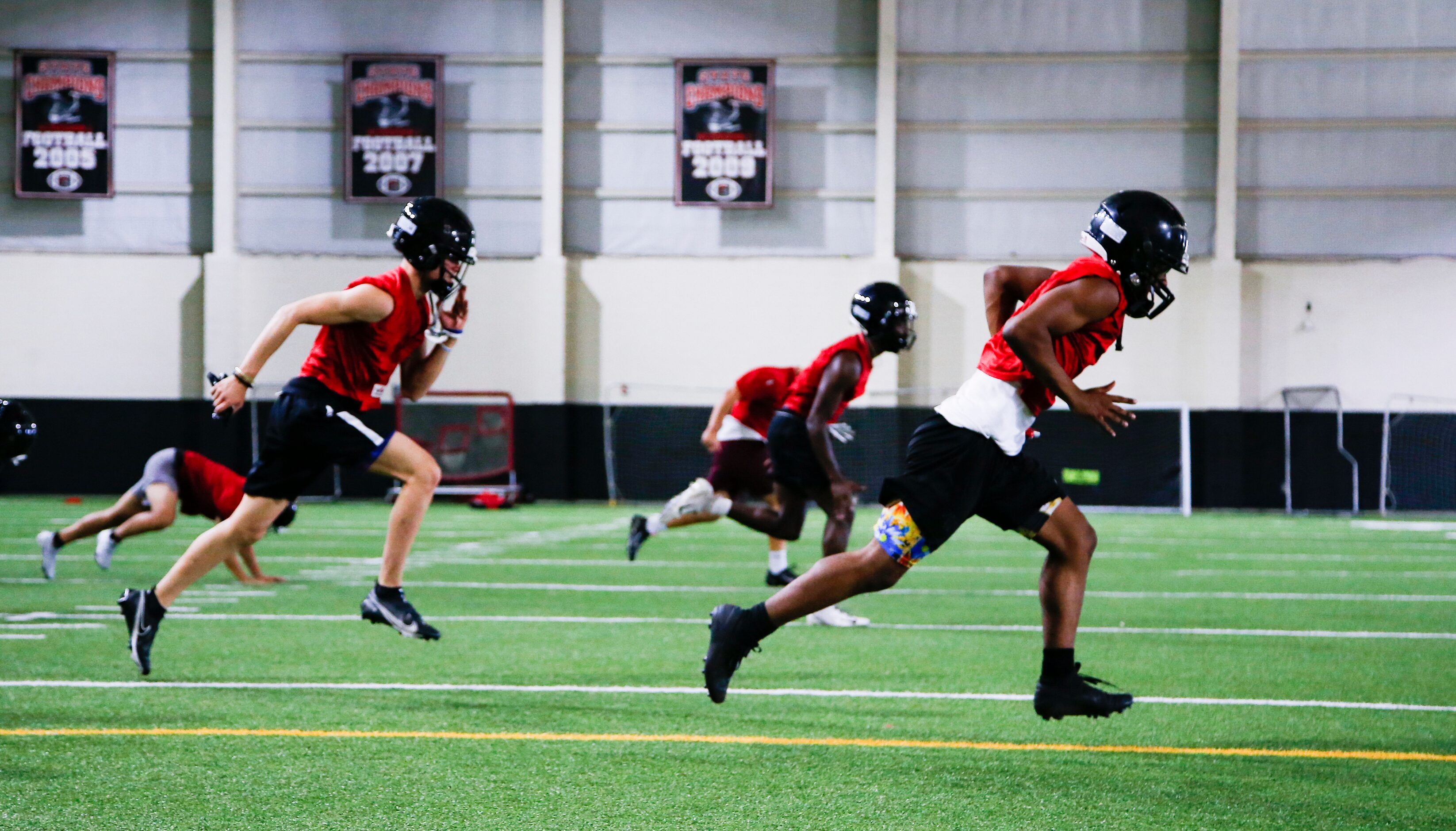 Euless Trinity’s varsity football team runs drills during a practice at Euless Trinity High...