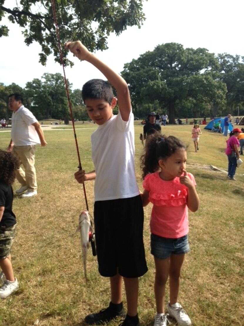 
Aubree Valdez is distracted while her friend Gabriel Trigo holds up his catch.
